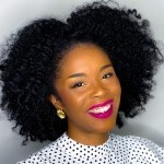 A photo of Ashley Cloud smiling with business casual wear and hair in an afro. 