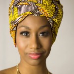 Woman in a bright yellow, red and black turban and gold necklace