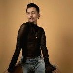 Peet is a light brown skinned nonbinary Filipino/a/x/? person seated before a beige background. They sit with one shoulder tilte