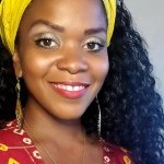 Smiling woman with yellow headwrap, curly black hair, red blouse with yellow and gold dots