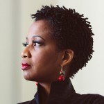 Profile picture of Dr. Sheyi in a black shirt and red earrings.