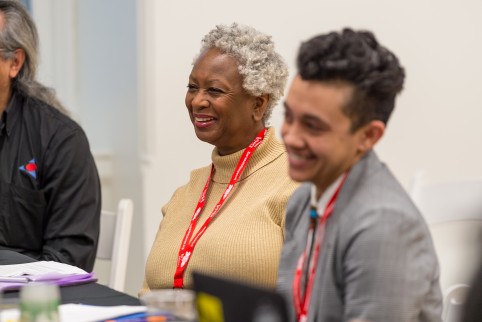 Three people sit smiling looking to the left. 
