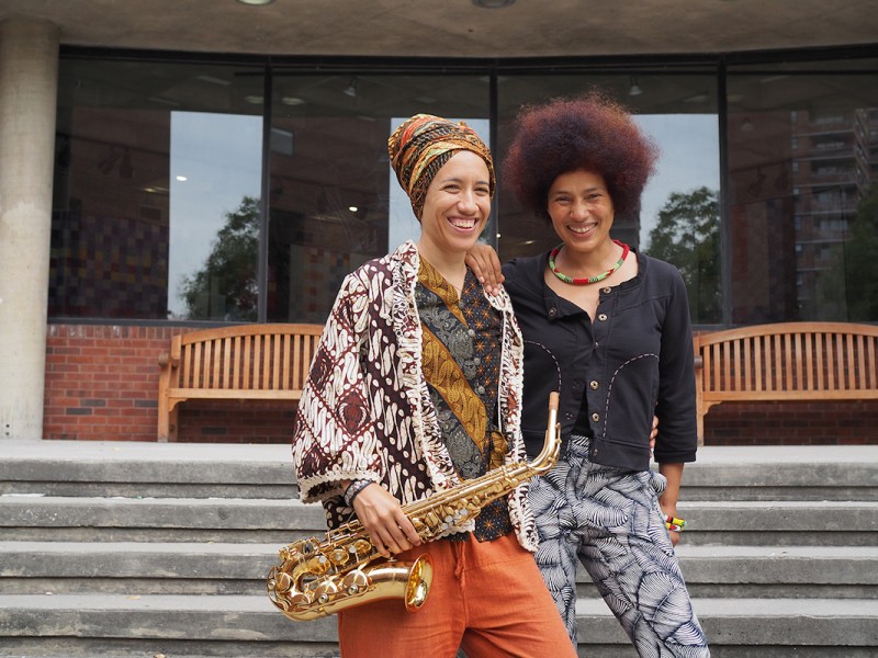 Oxana Chi and Layla Zami (holding a saxophone) standing in front of the Abrons Arts Center