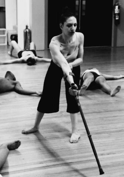 a woman dancer using a crutch to lean forward