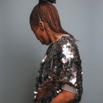 professional photo with black woman facing backwards with silver, sparkly short sleeve jacket!