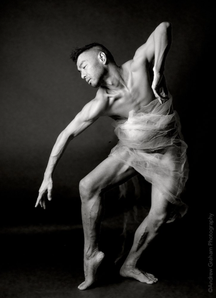 Black and white image of Peter in a dance pose with clear satin fabric