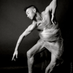 Black and white image of Peter in a dance pose with clear satin