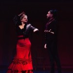 A Flamenco dancer with a red skirt and a singer with a black suit