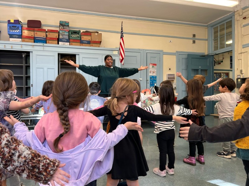 Image of dance teacher in front of a class of Kindergarden students during a Creative Dance class warm up