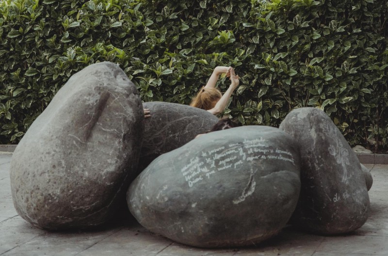 MIngled amongst circular boulders engraved with poems, a dancer (s) emerges from the stillness of the crevices that they create