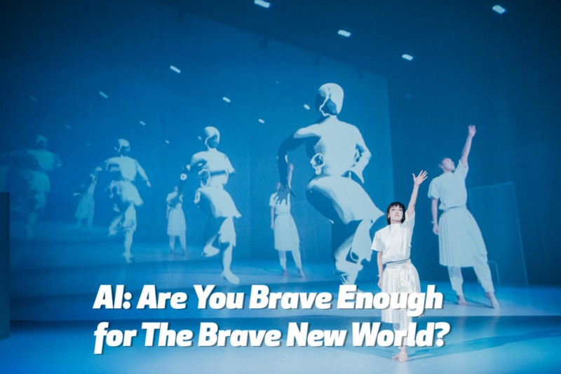 A dancer from "discrete figures 2019" in all white in front of a dark sky blue projection of robotic figures marching forward.