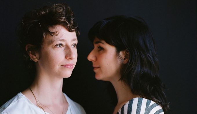 Eleanor Smith on the left looking to the right in the distance while Molly Liber stands beside her, facing Molly.