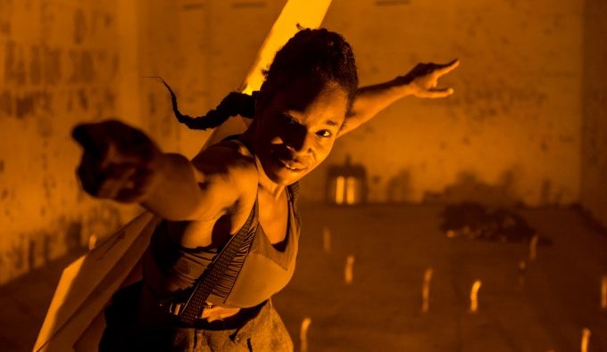 In a sepia tone, Marjani reaching her hand out to the viewer.