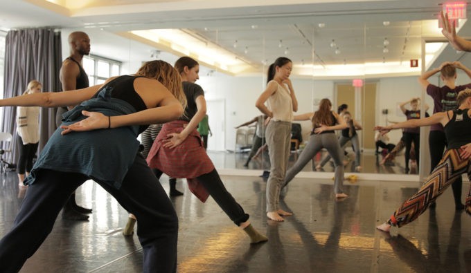 Dancers in a studio facing different directing creating shapes with their bodies. 