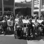Black and White Photo - Group of wheelchair users in front of the fountain at Lincoln Center