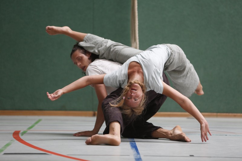 Woman balanced upside down on the back of another women on her knees.