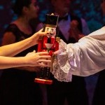 Nutcracker Figure being passed between two people