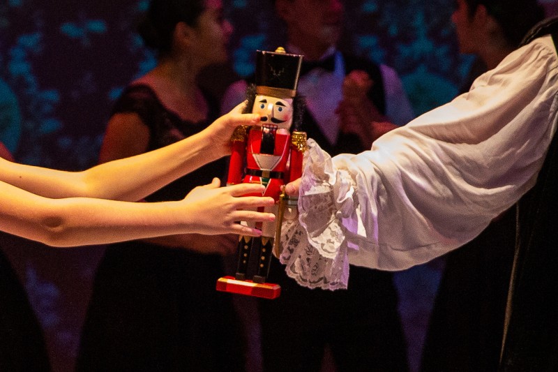 Nutcracker Figure being passed between two people