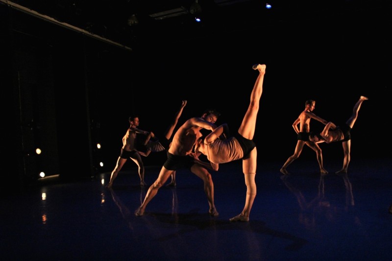 Group of dancers partnering on stage during a performance.