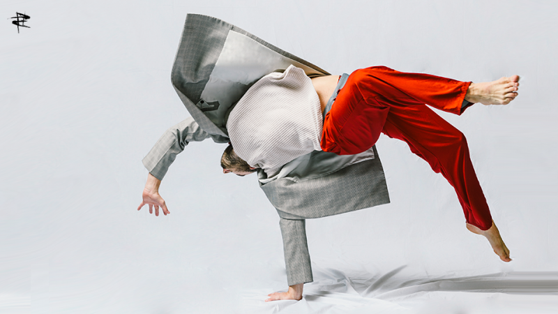 Dancer in red pants and blazer doing a flip.