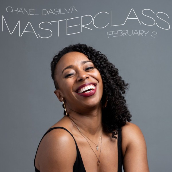 Headshot of a Black woman against a grey background with a big smile and her head tilted slightly back. She wears loose black le