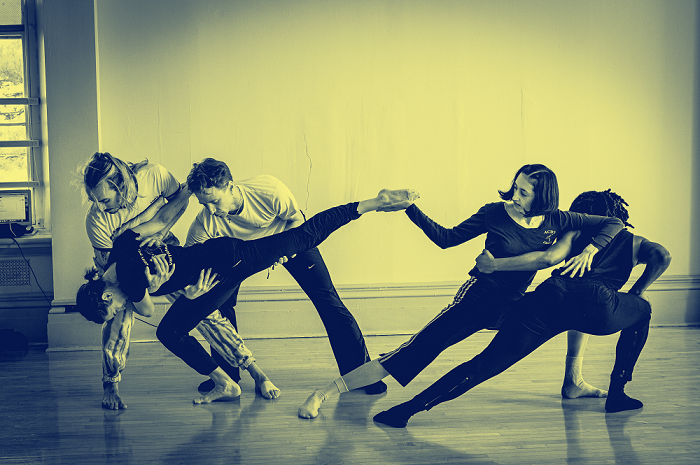 five dancers from Stephen Petronio dance company in blue and yellow duotone, with two leaning left, two leaning right, one in md