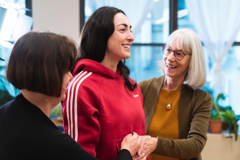 A student in red smiling while receiving hands-on from a trained Alexander Technique teacher