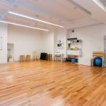sunny dance studio with hardwood floor, various movement equipment, and stools