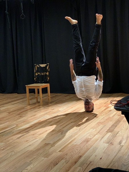A performer stands on his head during a performance in the Balance Arts Center's Karl Kemp Performance Space