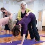 AT teacher helps student with downward dog yoga pose