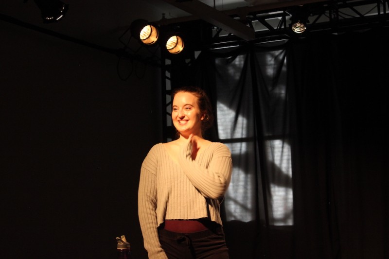 An actor smiles at the audience while performing a monologue at a Balance Arts Center Performance Showcase