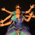 Three dancers stand in a row with arms extend out to the side during a performance at the BAC