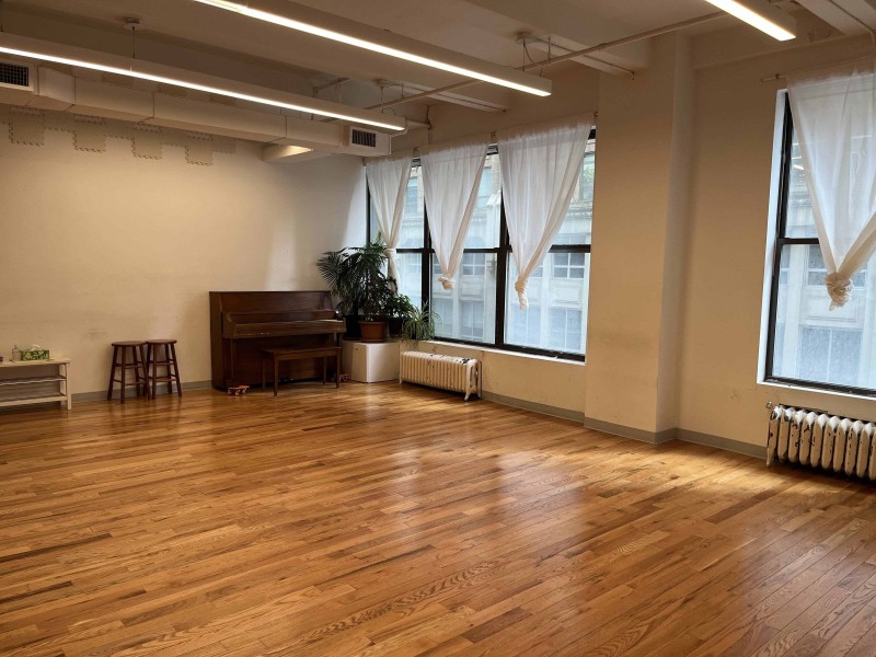 Studio with a piano, windows, hardwood floor