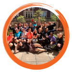 A group of past participants outside posing for a group photo