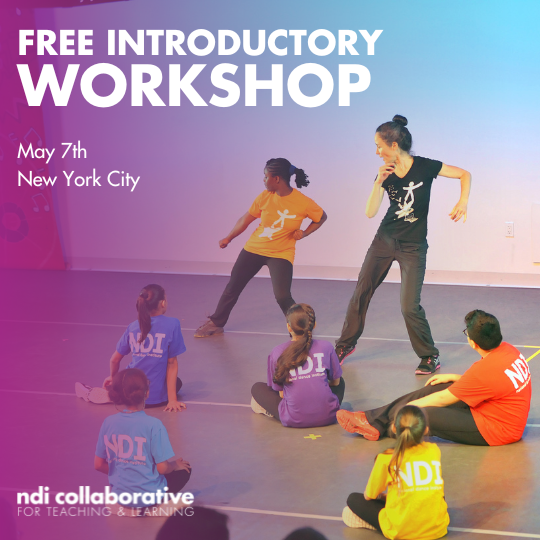 A teacher and a student dancing in front of a group of students.