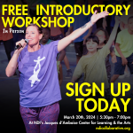 Female dance teacher stands in front of a group of children with one arm open to the side and the other holding a mic