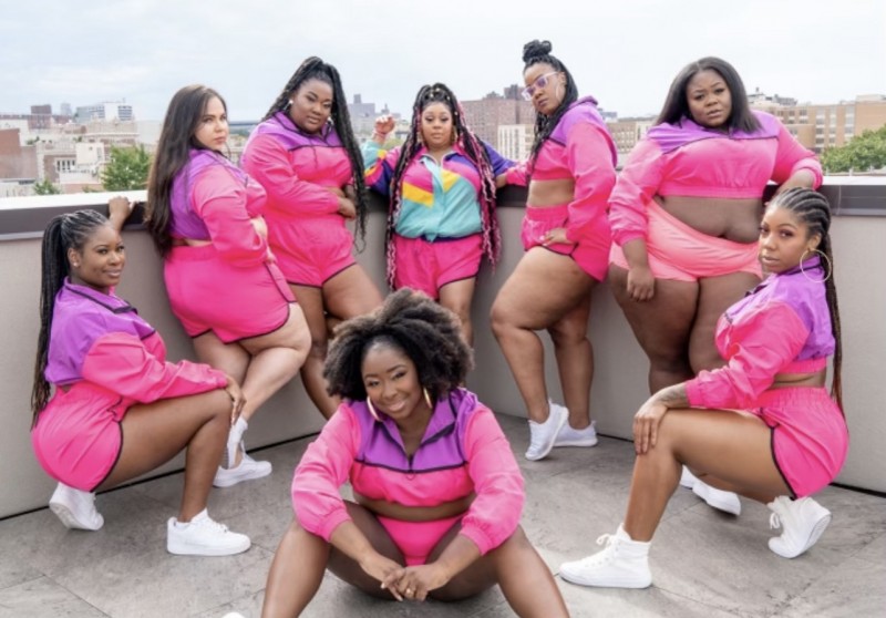 A group of women in pink outfits smiling