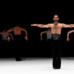 Multiple dancers on stage with arms extended