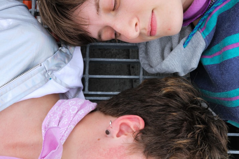 Pax  looking at Theo’s back of head with a faint smile 