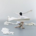 dancer swirling at mid-level with pieces of white fabric