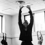 Three sufferers reaching towards the sky in a rehearsal studio. 