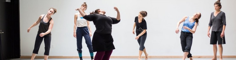 Alexandra Beller Spiraling in a dance studio, looking back at students who look on spiraling on their own.
