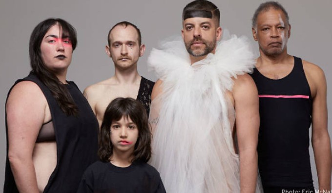 A portrait of queer latinx artist, Miguel Guiterrez, wearing a white costume with a white tulle collar.