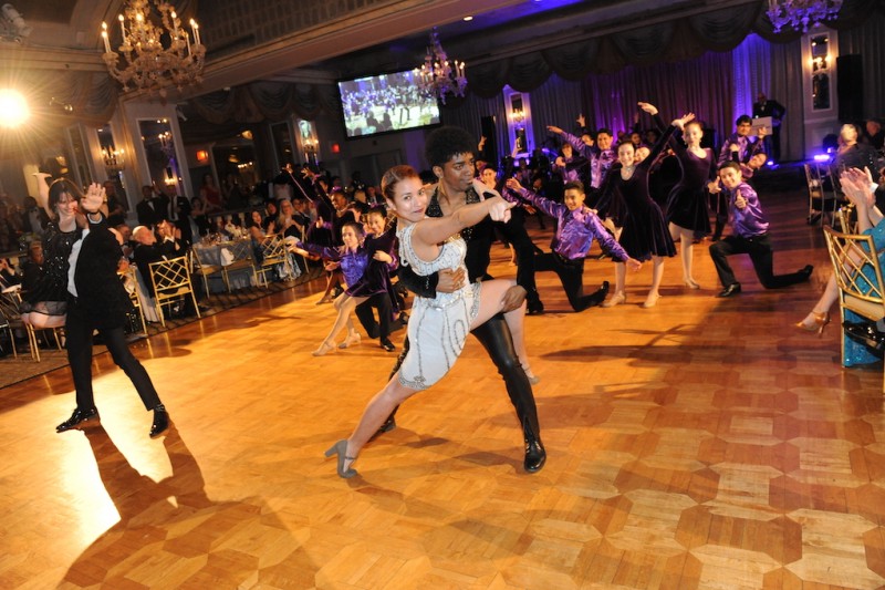 Two people dancing as partners on a ballroom floor.