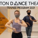 Two dancers photographed from the torso up, with their right hand pointed up and their left hand pointed downwards.