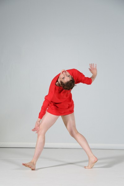 Woman facing back and arching back causing head to face towards us. 