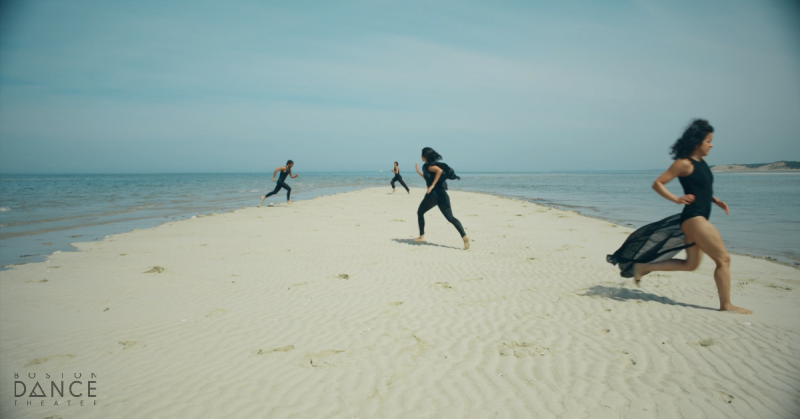 Dancers running on sandbar.
