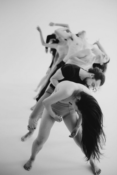 Black and white photograph of a line of dancers in motion