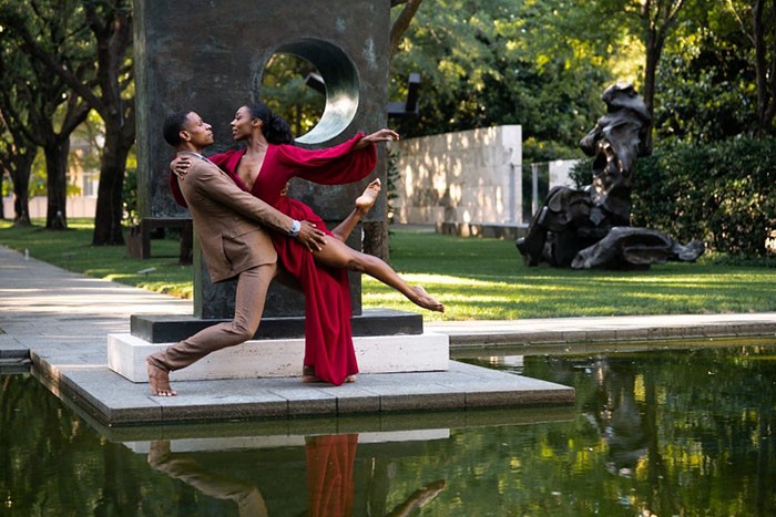 Image of two Dallas Black Dance Theatre dancers partnering outdoors by a pond