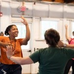 Curriculum in Motion participants dance with each other in a well lit studio